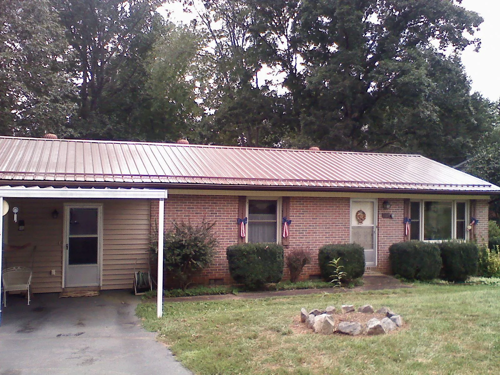 Bronze metal roof and carport on a brick ranch home — Roof Repair work by our crew in Kendalia