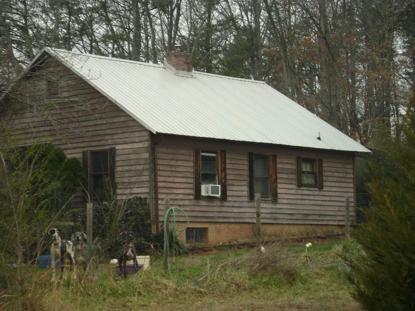White metal roof on an old wood sided farmhouse, from a Metal Roof Installation job in Kendalia